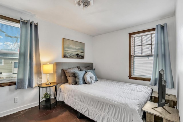 bedroom with finished concrete flooring and baseboards