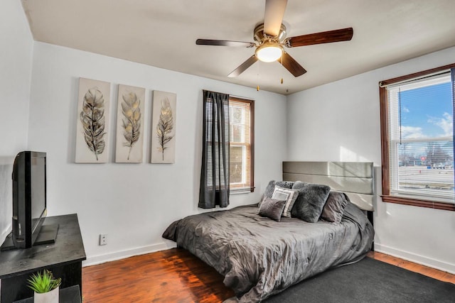 bedroom featuring ceiling fan, wood finished floors, and baseboards