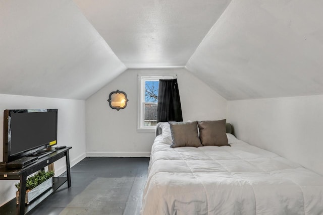 bedroom featuring lofted ceiling and baseboards