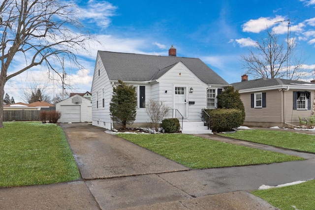 view of front of house with an outbuilding, a shingled roof, fence, driveway, and a front lawn