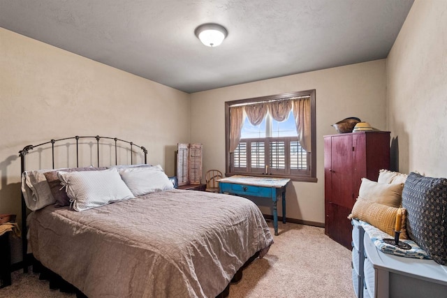 bedroom featuring baseboards and light colored carpet