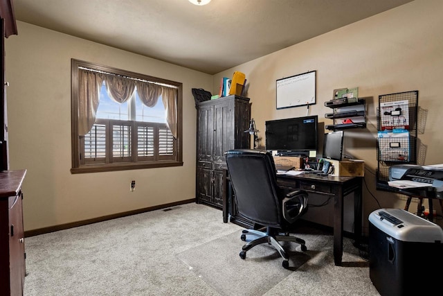 carpeted home office featuring baseboards