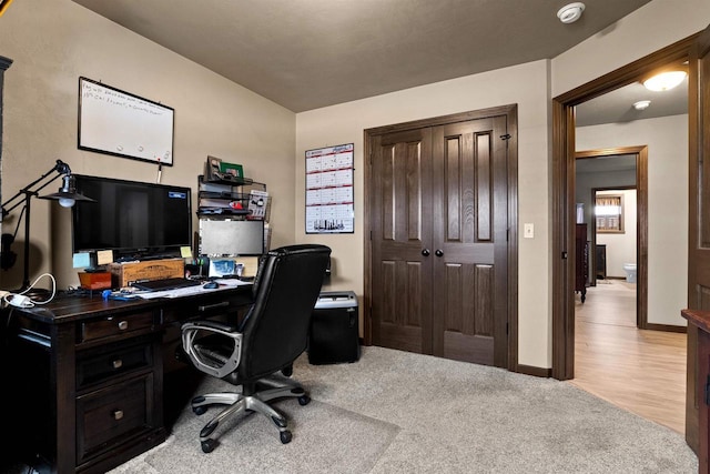 carpeted home office with baseboards and wood finished floors