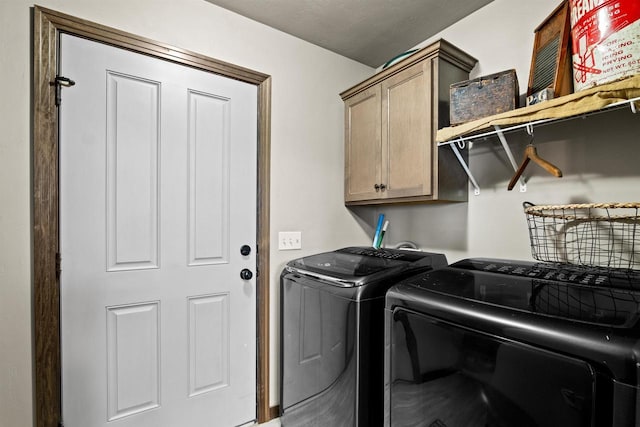 laundry room with washing machine and dryer and cabinet space