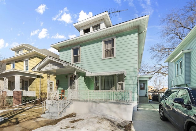 american foursquare style home featuring covered porch