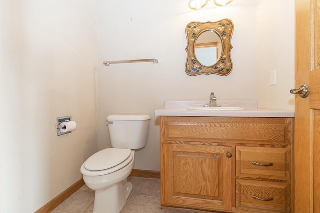 half bath with baseboards, vanity, toilet, and tile patterned floors