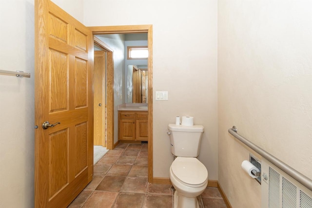 half bath with vanity, toilet, and baseboards