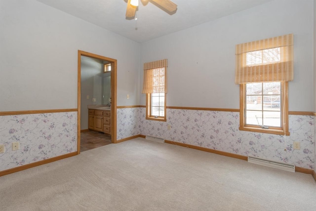 spare room featuring baseboards, carpet flooring, a ceiling fan, and wallpapered walls