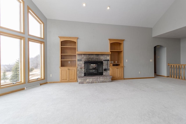 unfurnished living room featuring baseboards, a fireplace, visible vents, and a wealth of natural light