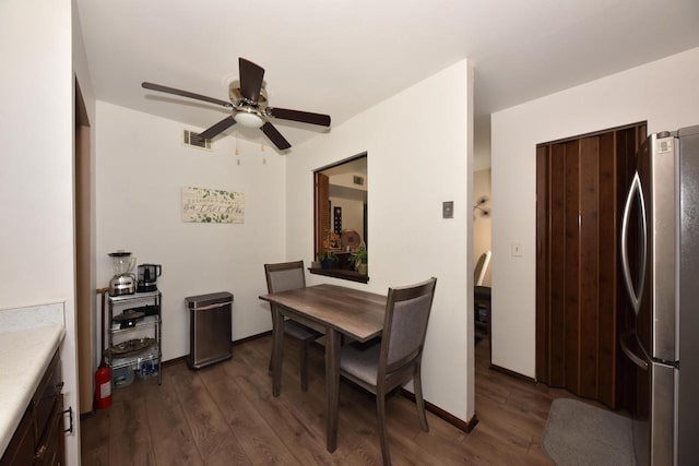 dining area featuring ceiling fan, dark wood-style flooring, visible vents, and baseboards