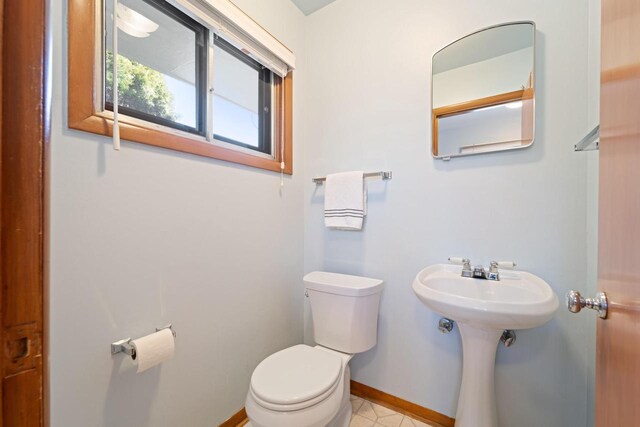 bathroom with toilet and baseboards