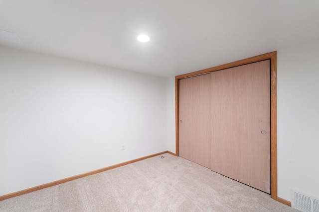 unfurnished bedroom with a closet, carpet flooring, visible vents, and baseboards