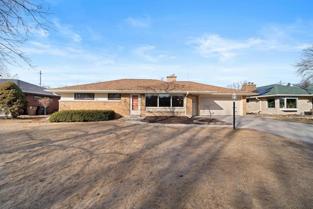 ranch-style home featuring driveway, brick siding, a chimney, and an attached garage