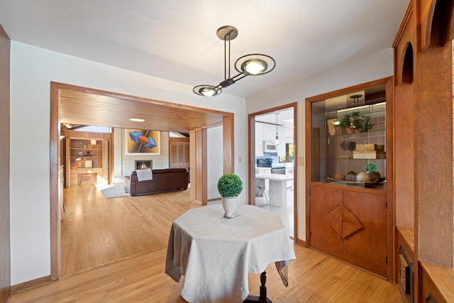 dining space featuring a fireplace and light wood-style flooring