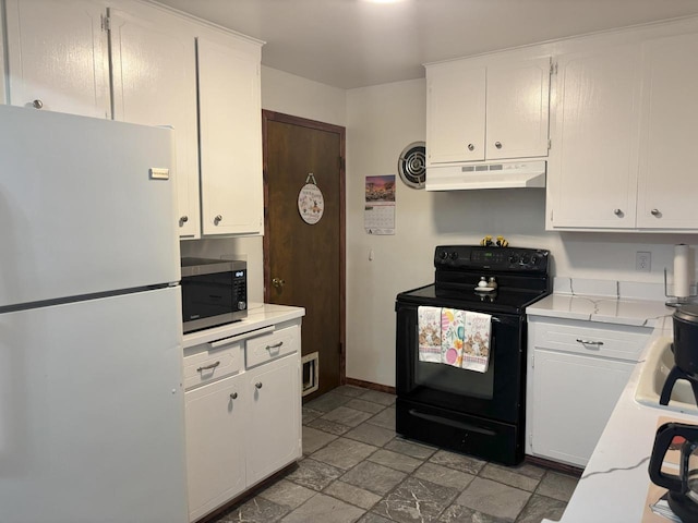 kitchen with stone tile floors, stainless steel microwave, freestanding refrigerator, black / electric stove, and under cabinet range hood