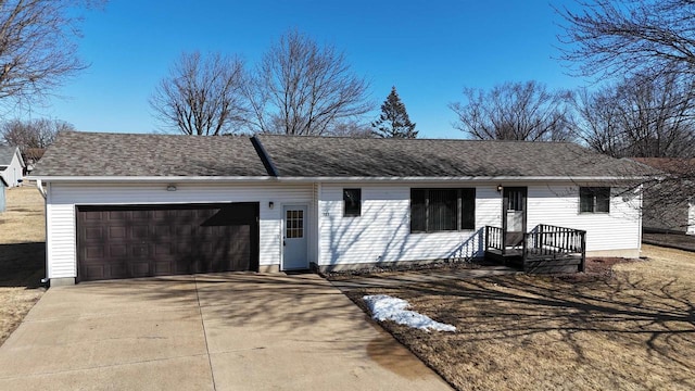 ranch-style home featuring driveway, a shingled roof, and an attached garage