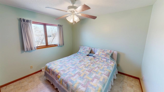 bedroom featuring ceiling fan, baseboards, and a textured ceiling