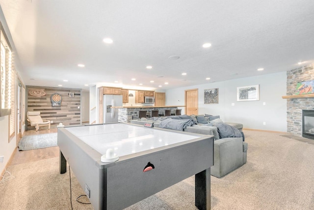 N8111 Castaway Dr, New Lisbon, WI 53950 - recreation room featuring a fireplace, recessed lighting, an accent wall, light carpet, and baseboards