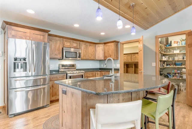 N8111 Castaway Dr, New Lisbon, WI 53950 - kitchen with stainless steel appliances, a breakfast bar, a sink, light wood-type flooring, and a center island with sink