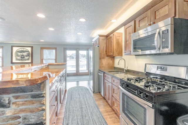 N8111 Castaway Dr, New Lisbon, WI 53950 - kitchen featuring light wood finished floors, appliances with stainless steel finishes, a textured ceiling, a sink, and recessed lighting
