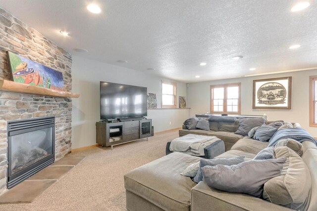 N8111 Castaway Dr, New Lisbon, WI 53950 - living room featuring a textured ceiling, a stone fireplace, carpet flooring, and baseboards