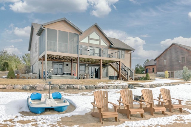 N8111 Castaway Dr, New Lisbon, WI 53950 - snow covered rear of property featuring a sunroom, stairs, and a deck
