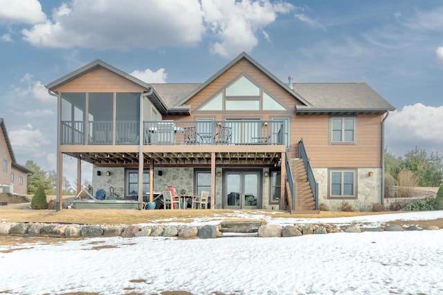 N8111 Castaway Dr, New Lisbon, WI 53950 - snow covered house with stone siding, stairway, a deck, and french doors