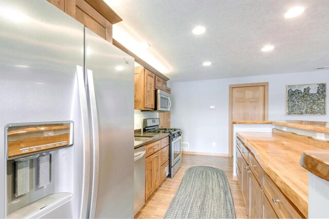 N8111 Castaway Dr, New Lisbon, WI 53950 - kitchen with stainless steel appliances, recessed lighting, butcher block counters, a textured ceiling, and light wood-type flooring