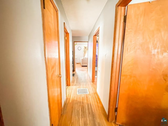 corridor featuring light wood finished floors and visible vents