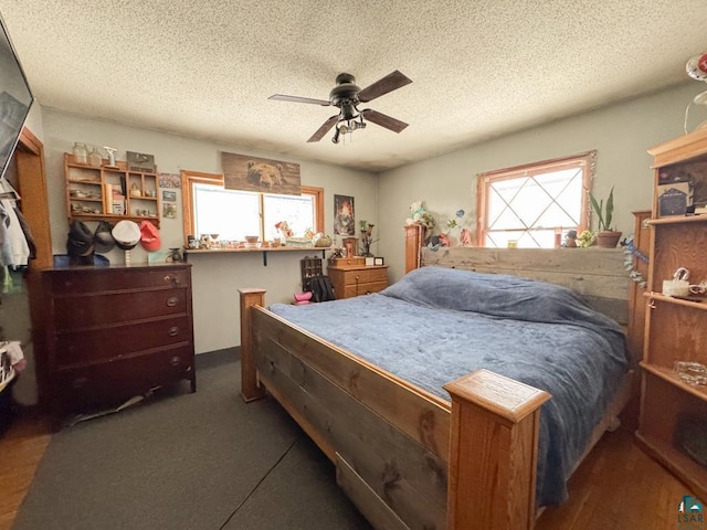 bedroom with ceiling fan and a textured ceiling