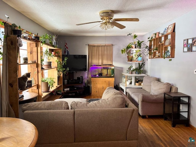 living room featuring a textured ceiling, a ceiling fan, and wood finished floors