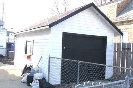 detached garage featuring fence