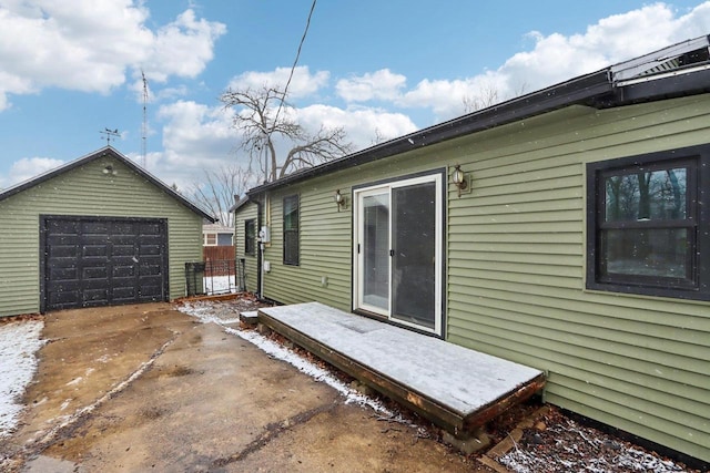 exterior space featuring a garage, an outbuilding, and concrete driveway