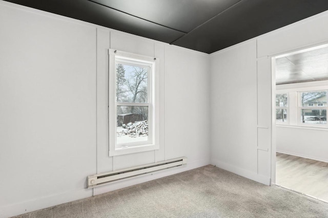 carpeted spare room with a wealth of natural light and a baseboard radiator