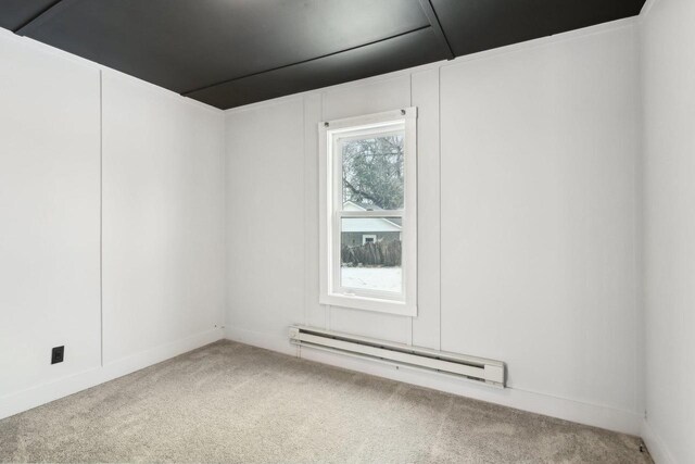 carpeted spare room featuring baseboard heating