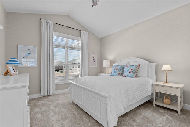 bedroom featuring lofted ceiling, baseboards, and light colored carpet