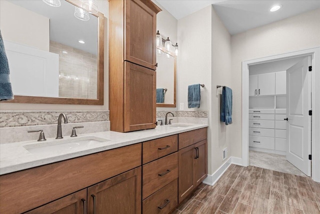 bathroom with wood finished floors, a sink, visible vents, and decorative backsplash