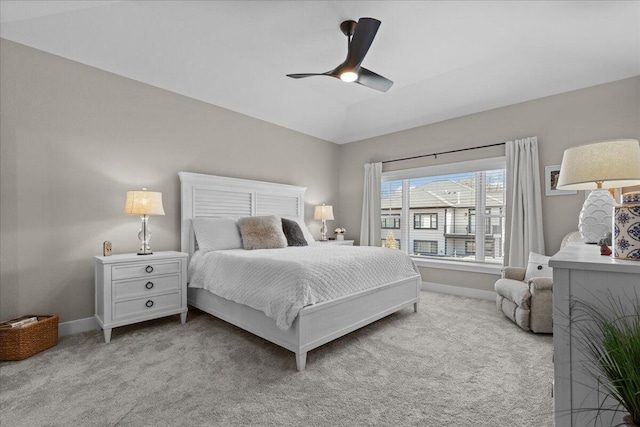 bedroom with baseboards, lofted ceiling, a ceiling fan, and light colored carpet