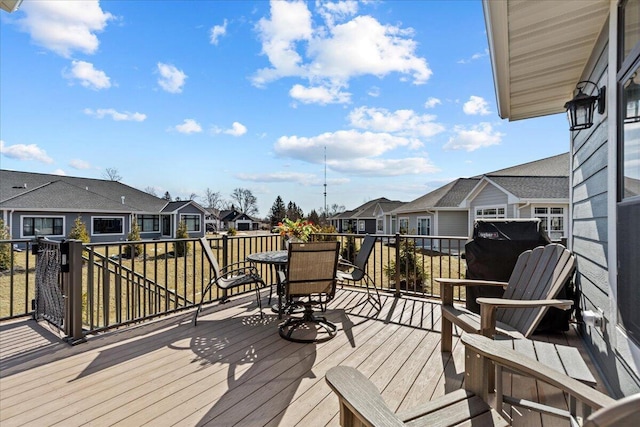 deck featuring a residential view, area for grilling, and outdoor dining space