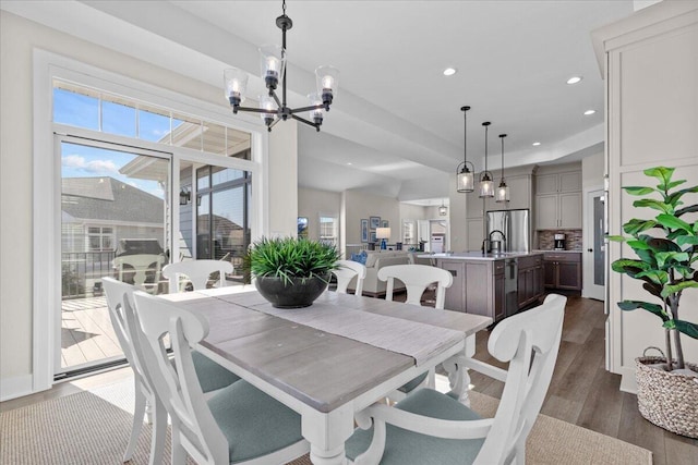 dining room with a chandelier, recessed lighting, a healthy amount of sunlight, and dark wood finished floors