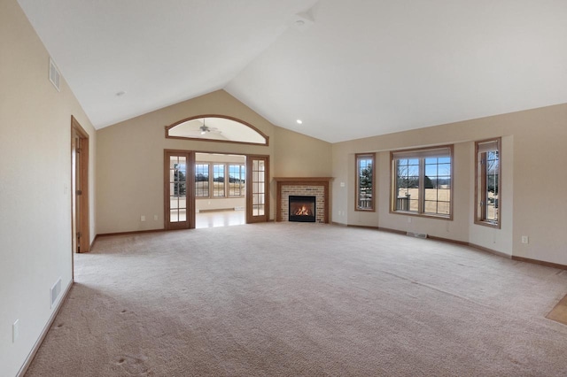 unfurnished living room featuring light carpet, high vaulted ceiling, visible vents, and a healthy amount of sunlight