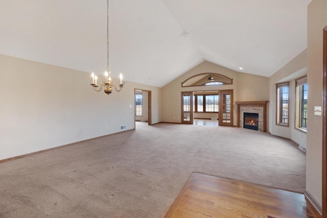 unfurnished living room featuring baseboards, visible vents, carpet, a fireplace, and high vaulted ceiling