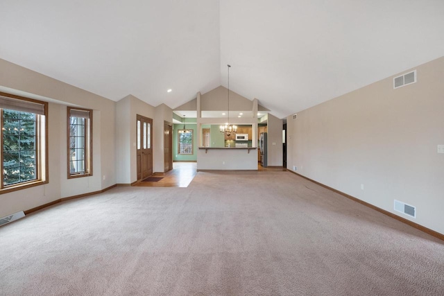 unfurnished living room with visible vents, light carpet, and an inviting chandelier