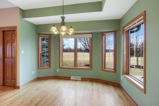 unfurnished dining area featuring light wood finished floors, visible vents, and a healthy amount of sunlight