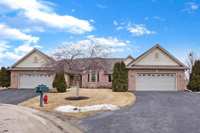 ranch-style home with an attached garage, stucco siding, driveway, and brick siding