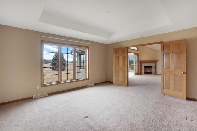 spare room featuring visible vents, a tray ceiling, and baseboards