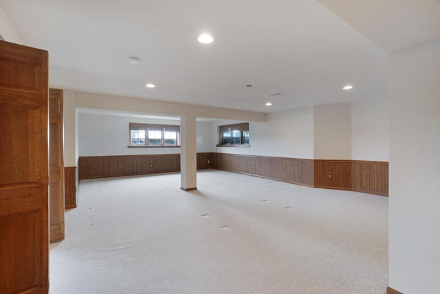 basement featuring carpet floors, recessed lighting, wainscoting, and wooden walls