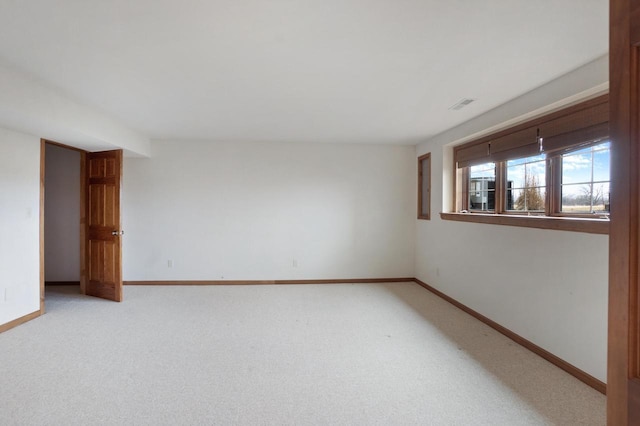 empty room with light colored carpet, visible vents, and baseboards