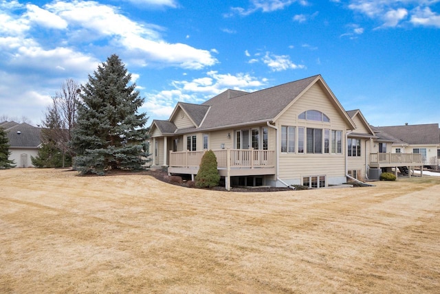 exterior space with a shingled roof, cooling unit, a lawn, and a deck