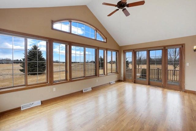 unfurnished sunroom with lofted ceiling, ceiling fan, and visible vents